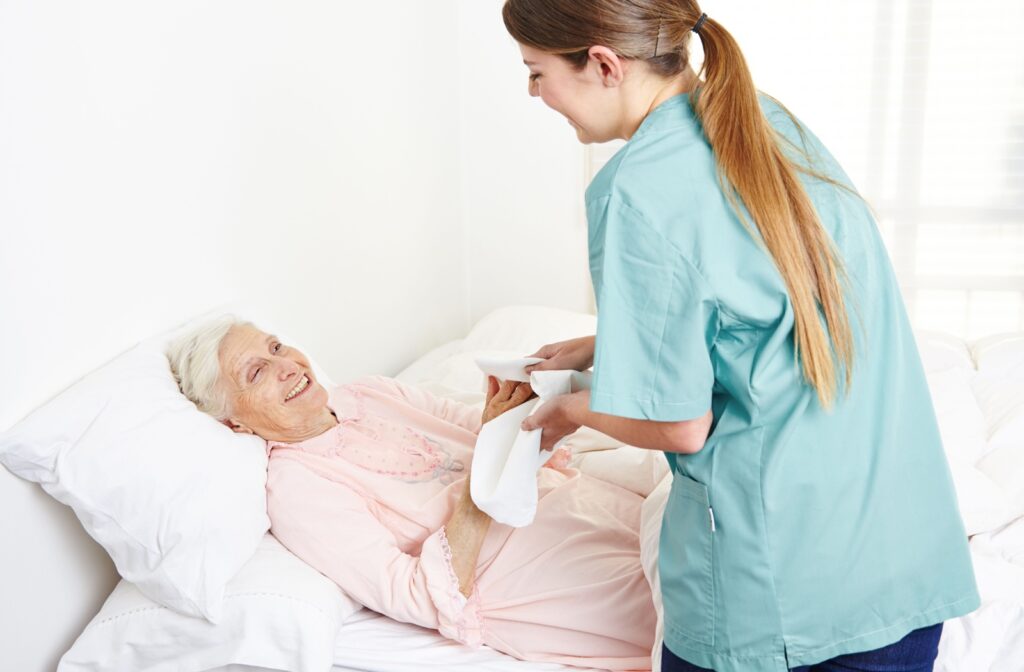 An older adult woman being assisted by a personal care staff.
