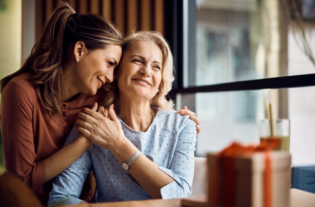 A woman hugging her elderly mother while enjoying spending time together.