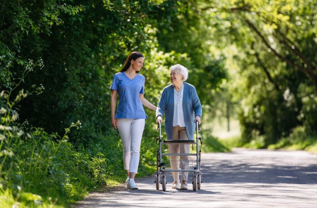 Senior resident in memory care in Pennsylvania taking a walk with a friendly caregiver.
