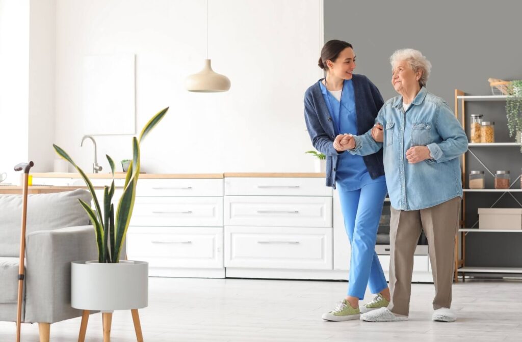A caregiver helps an appreciative resident walk across their apartment in their new home in personal care